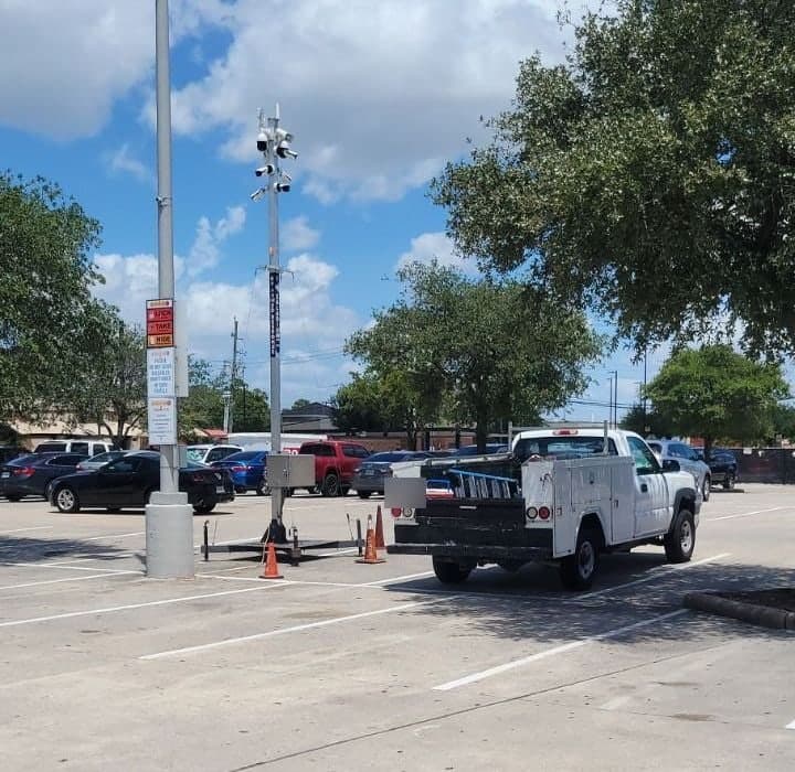 Torre móvil con cuatro cámaras en el estacionamiento de un centro comercial junto a una camioneta de servicio