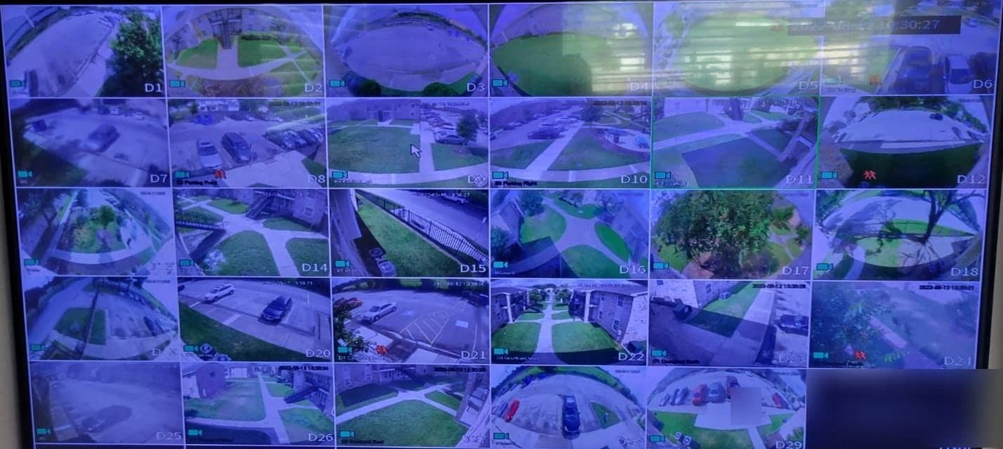 Pantalla del grabador con veintinueve vistas de cámara de los estacionamientos y patios de un complejo de apartamentos